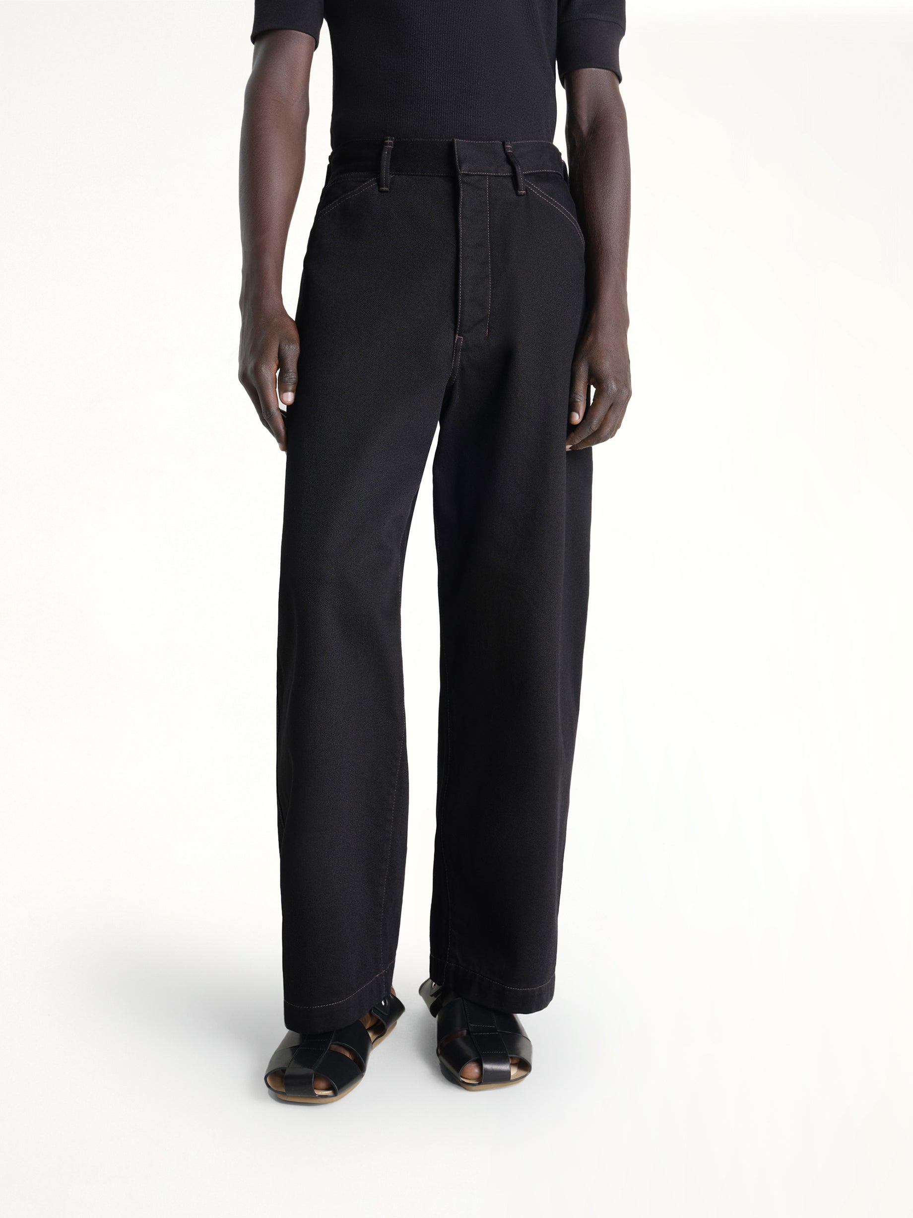 Image of a model wearing Pants. Product name - Maxi Workwear Pants in Black colour by brand - LEMAIRE
