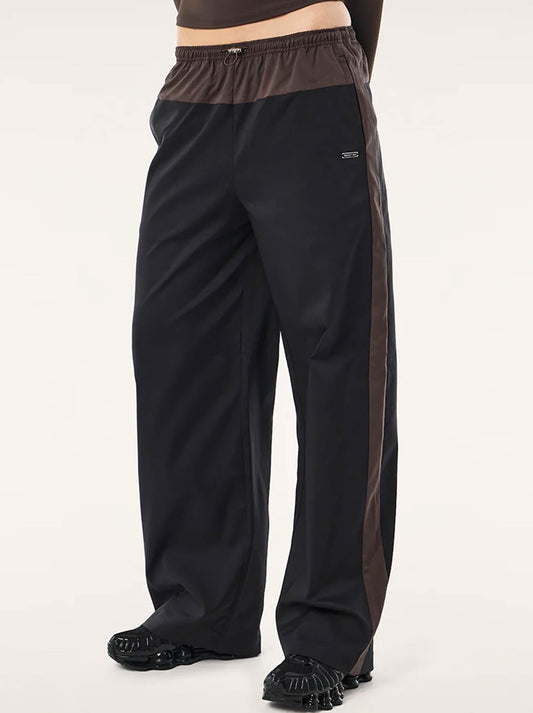 Image of a model wearing Pants. Product name - P.E NATION HALO PANT in Black Coffee colour by brand - P.E Nation
