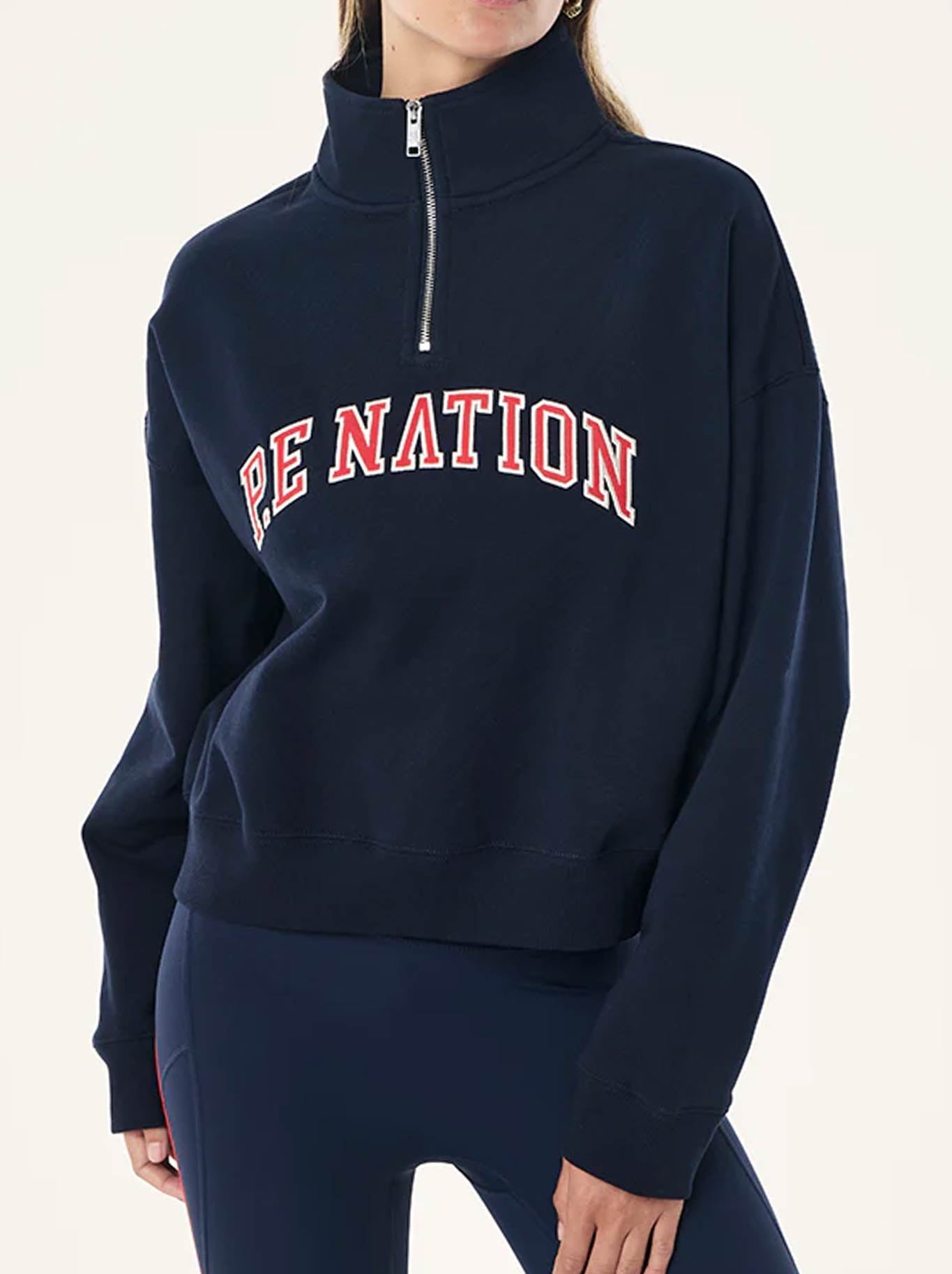 Image of a model wearing Tops. Product name - P.E NATION LEGACY QUARTER ZIP SWEAT in Dark Navy colour by brand - P.E Nation