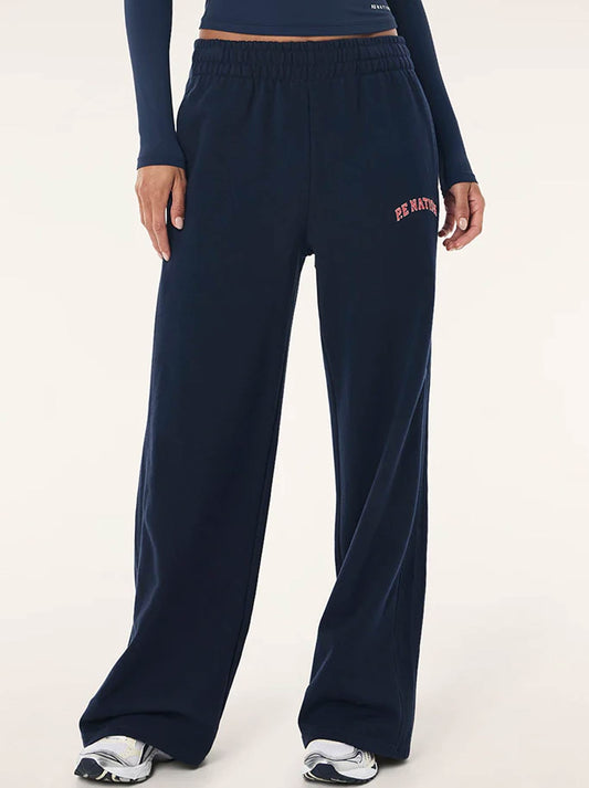 Image of a model wearing Pants. Product name - P.E NATION LEGACY TRACKPANTS in Dark Navy colour by brand - P.E Nation
