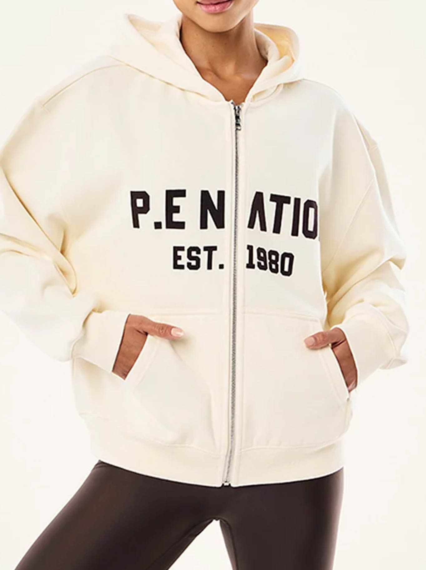 Image of a model wearing Tops. Product name - P.E NATION PHANTOM ZIP-THRU HOODIE in Whisper White colour by brand - P.E Nation