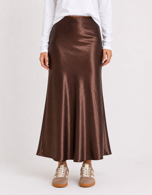 Image of a model wearing Skirts. Product name - Prodigy Satin Bias Cut Maxi Skirt Chocolate in Chocolate colour by brand - Stories Be Told