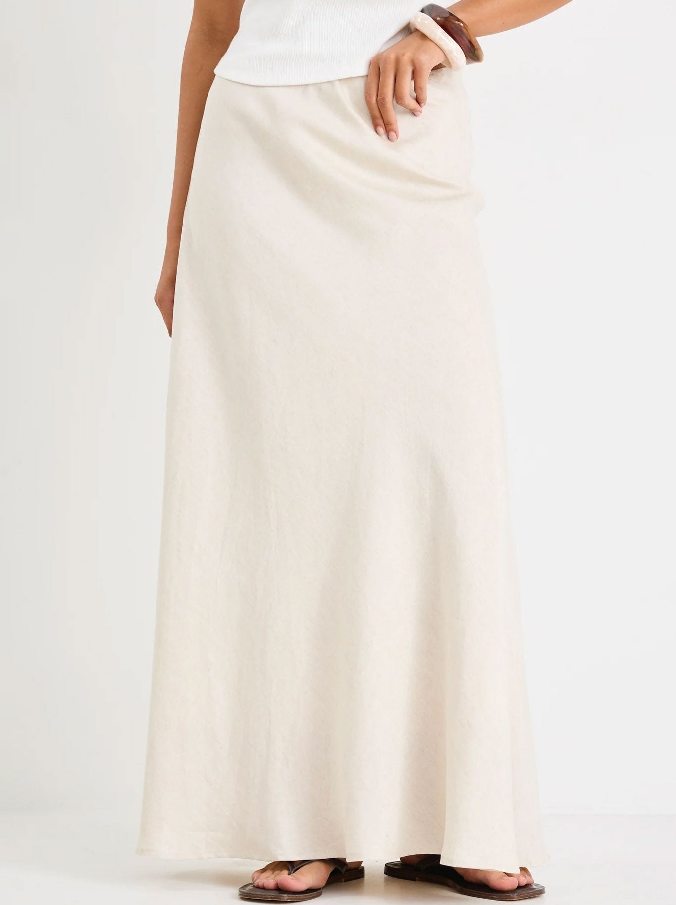 Image of a model wearing Skirts. Productname: RE:UNION THE LABEL LAGOS LINEN MAXI SKIRT in Natural colour by brand - Re:Union The Label