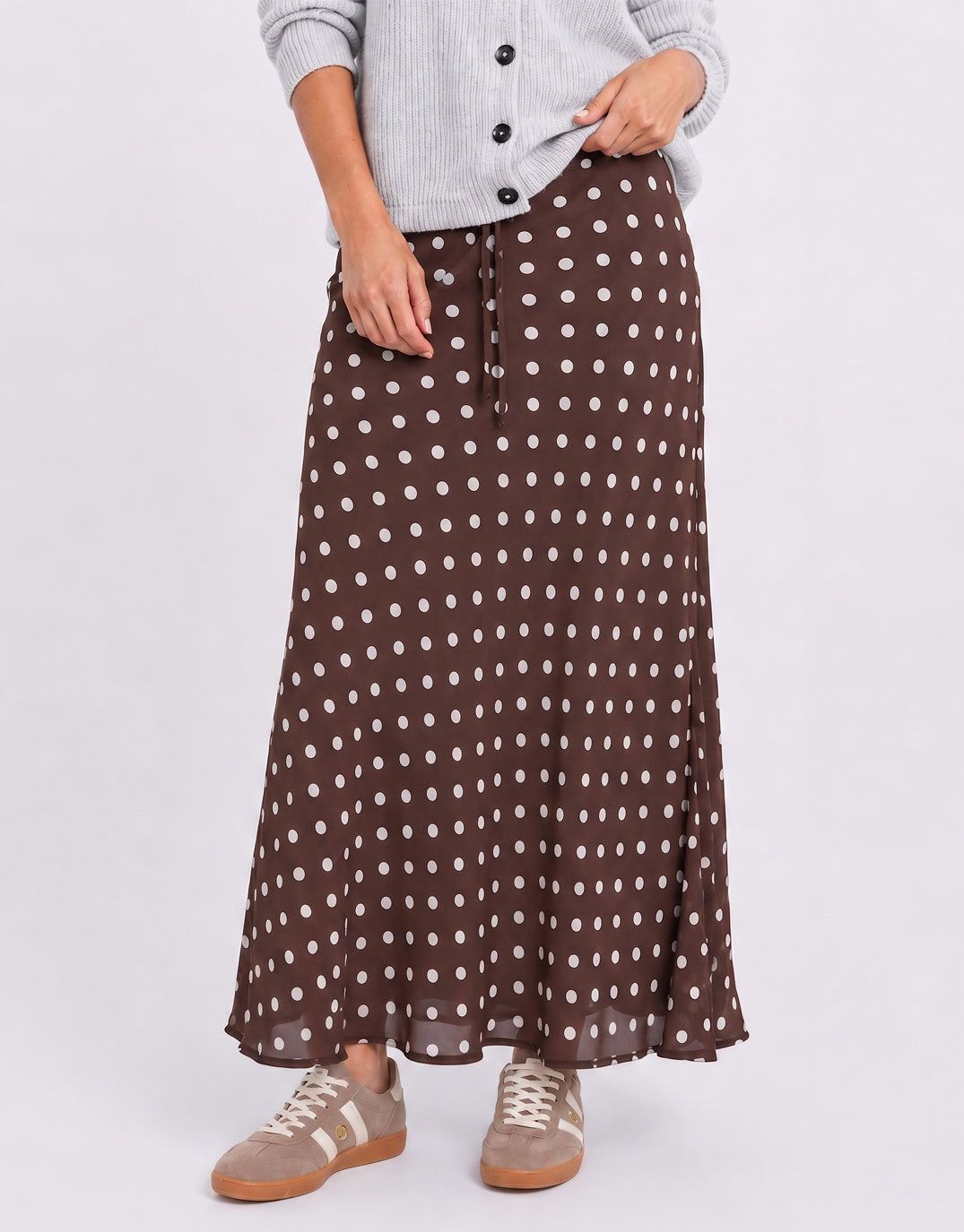Image of a model wearing Skirts. Product name - Rally Georgette Bias Cut Maxi Skirt Chocolate Polka Dot in Chocolate Polka Dot colour by brand - Among the Brave