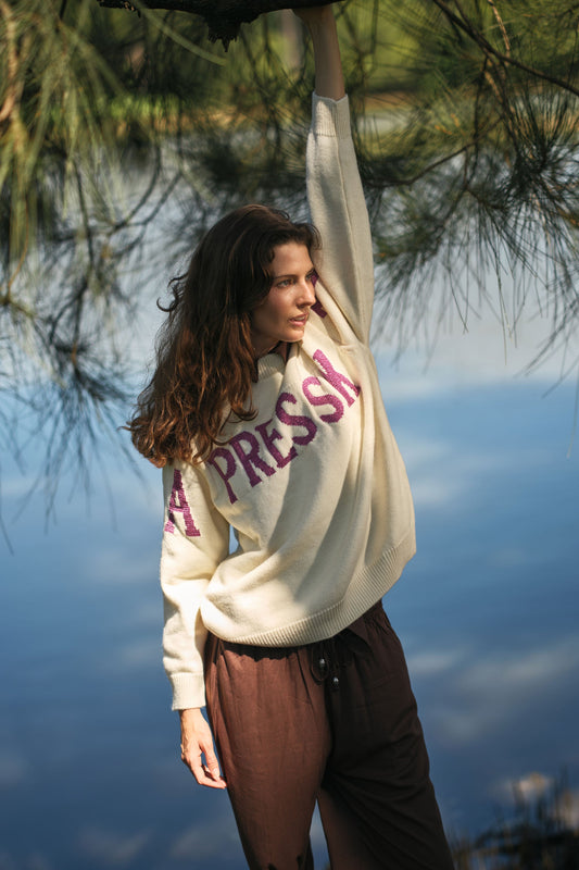 Image of a model wearing Outerwear. Product name - Rubyyaya Apres Ski Sweater Cream in Cream colour by brand - Rubyyaya