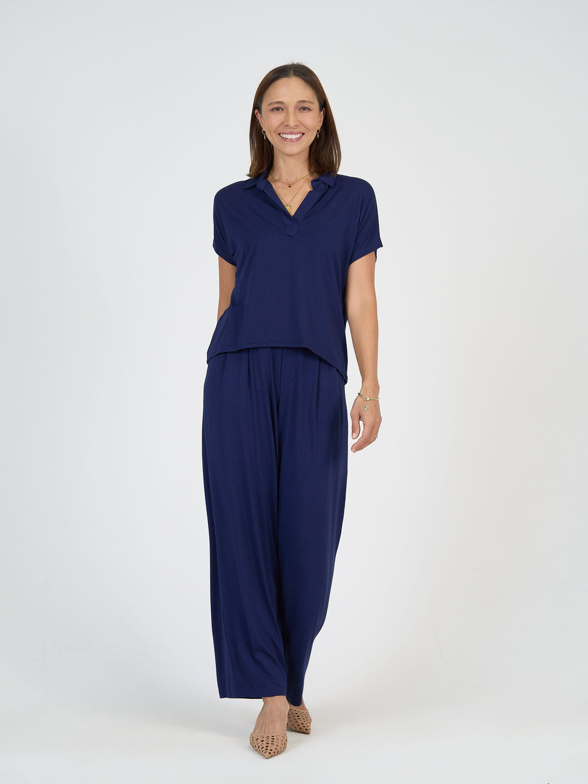 Image of a model wearing Tops. Product name - Rush Bamboo Short Sleeve Collared Polo Top Navy in Navy colour by brand - Lou Lou