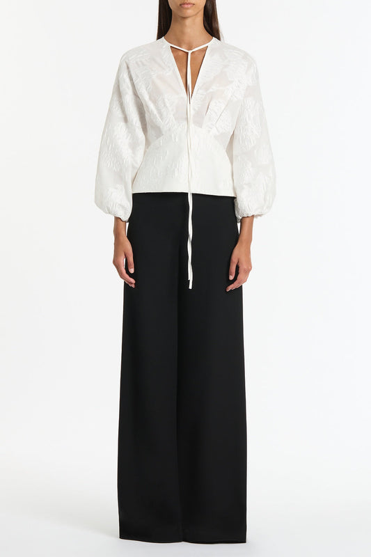 Image of a model wearing Tops. Product name - White Mesh Jacquard Puff Sleeve Blouse in White colour by brand - Carla Zampatti