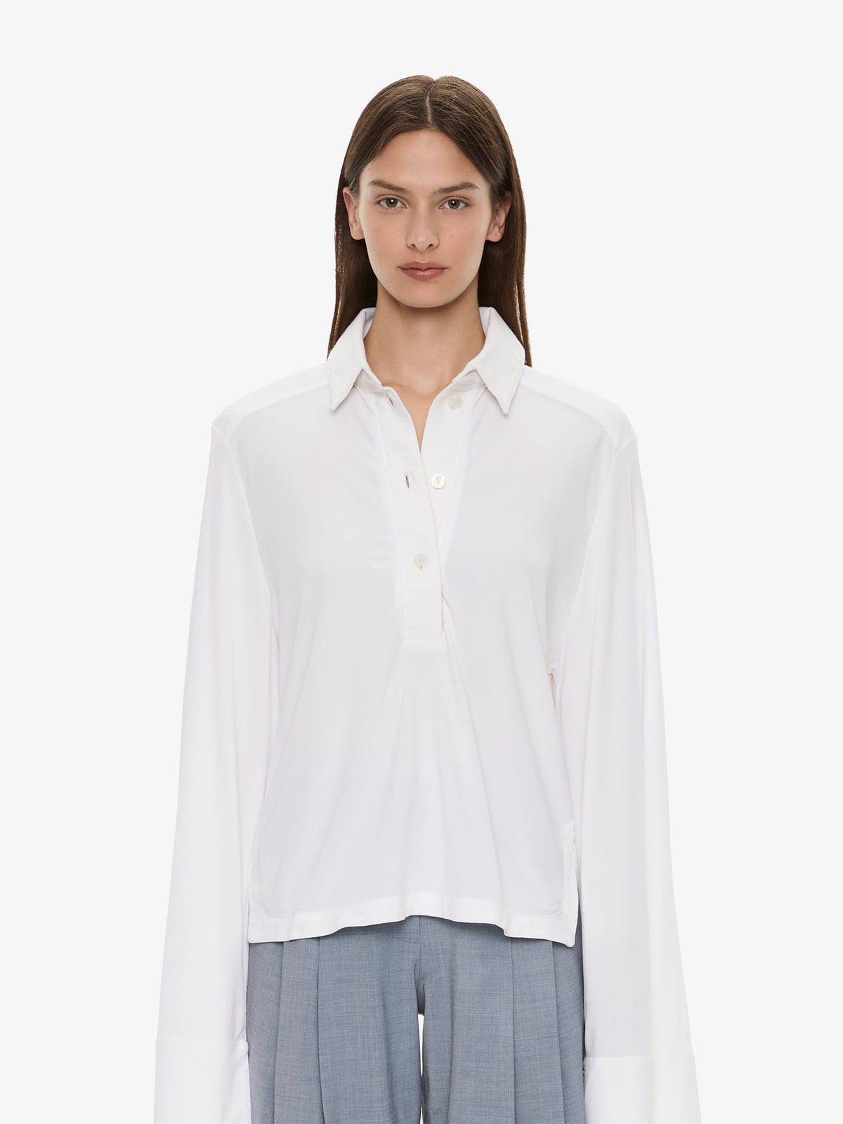 Image of a model wearing Tops. Product name - Deconstruct Denim Long Sleeve Polo in White colour by brand - CHRISTOPHER ESBER