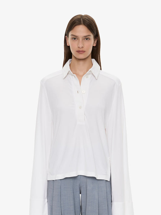 Image of a model wearing Tops. Product name - Deconstruct Denim Long Sleeve Polo in White colour by brand - CHRISTOPHER ESBER