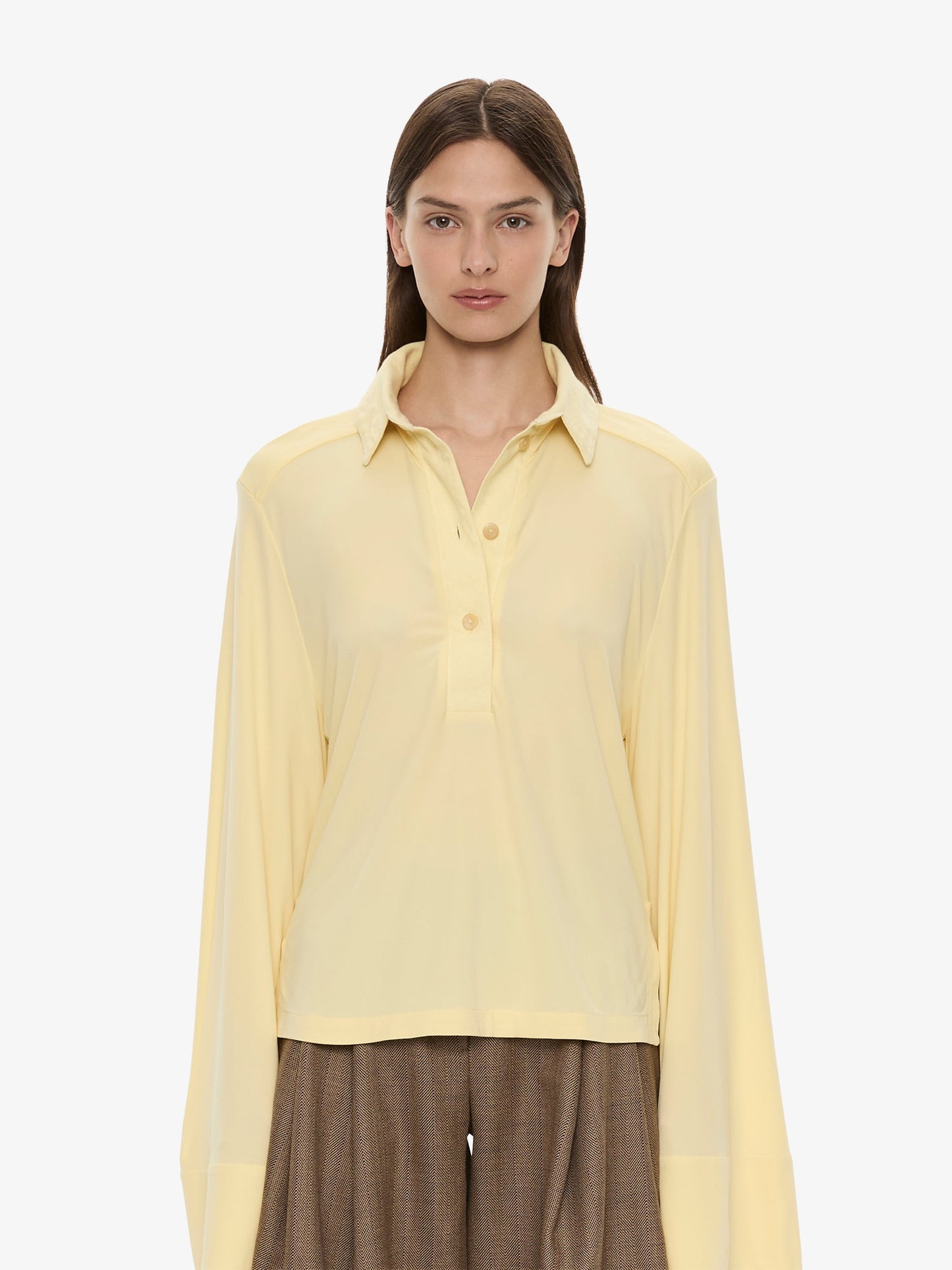 Image of a model wearing Tops. Product name - Deconstruct Denim Long Sleeve Polo in Butter colour by brand - CHRISTOPHER ESBER