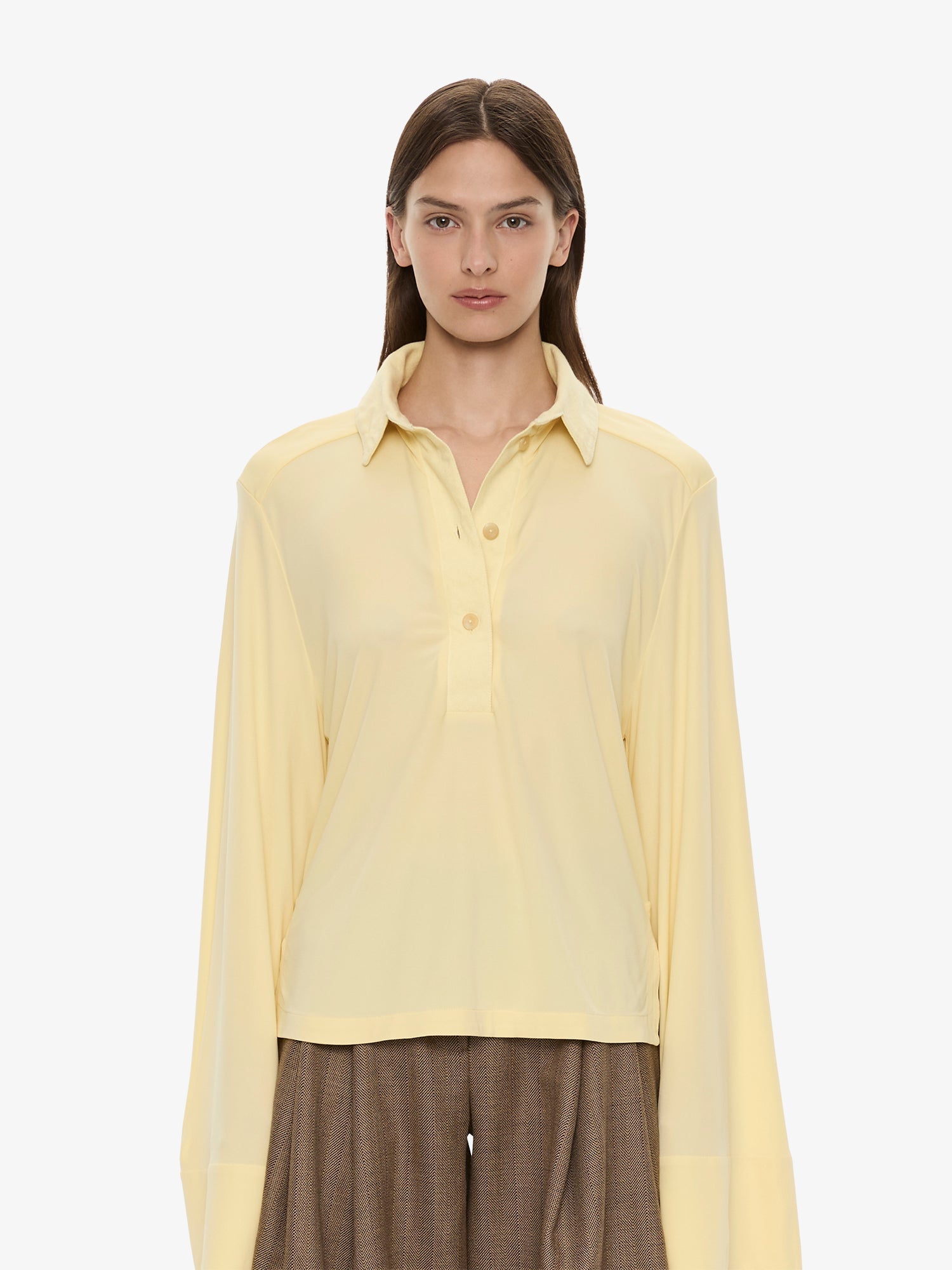 Image of a model wearing Tops. Product name - Deconstruct Denim Long Sleeve Polo in Butter colour by brand - CHRISTOPHER ESBER