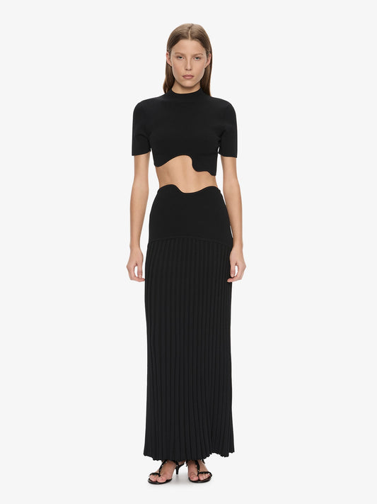 Image of a model wearing Skirts. Product name - Maparadita Pleated Skirt in Black colour by brand - CHRISTOPHER ESBER