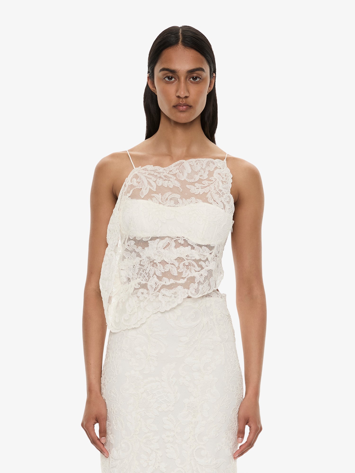 Image of a model wearing Tops. Product name - Reverie Floating Lace Cami in White colour by brand - CHRISTOPHER ESBER