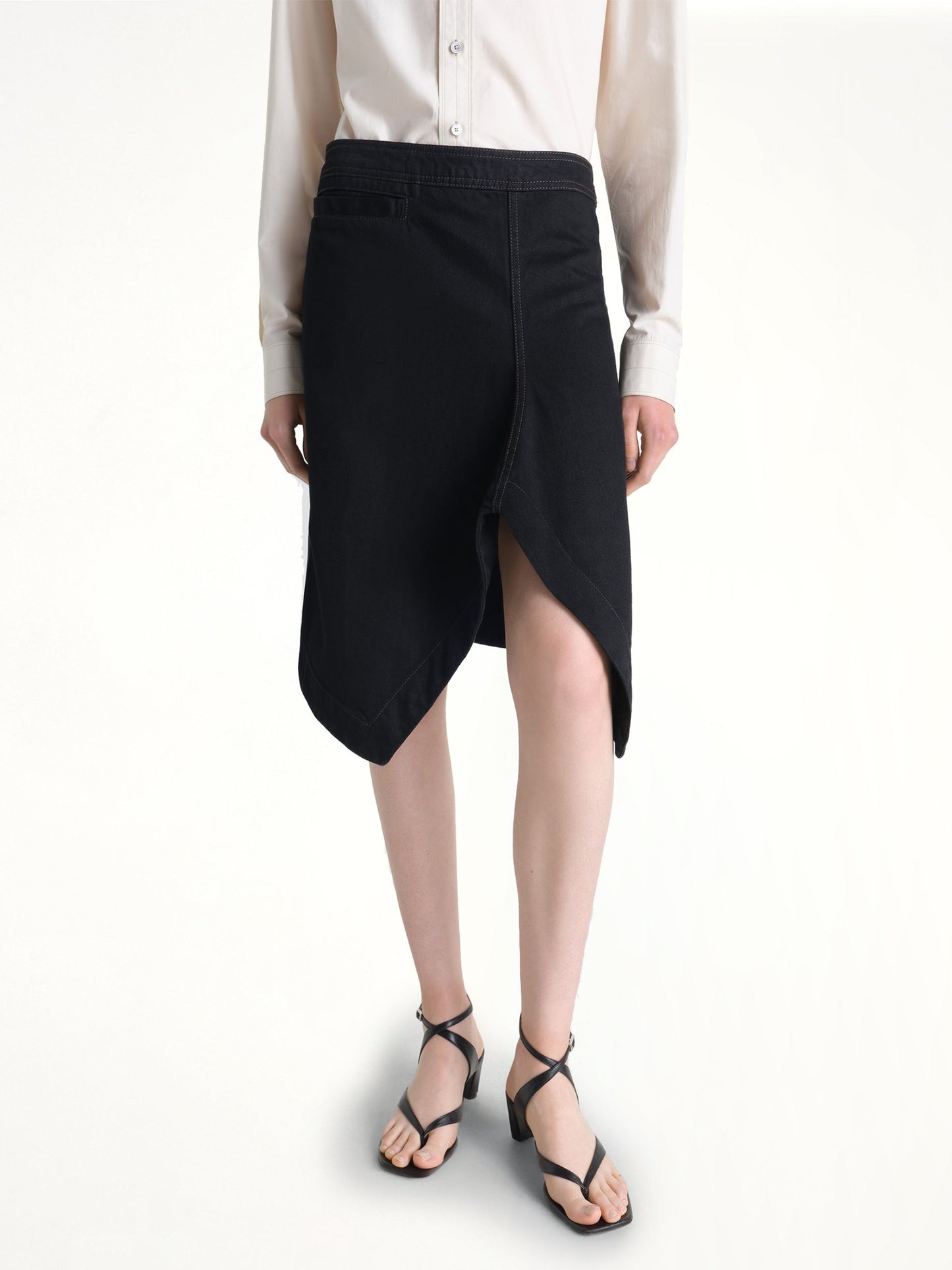 Image of a model wearing Skirts. Product name - Asymmetric Short Skirt in Black colour by brand - LEMAIRE