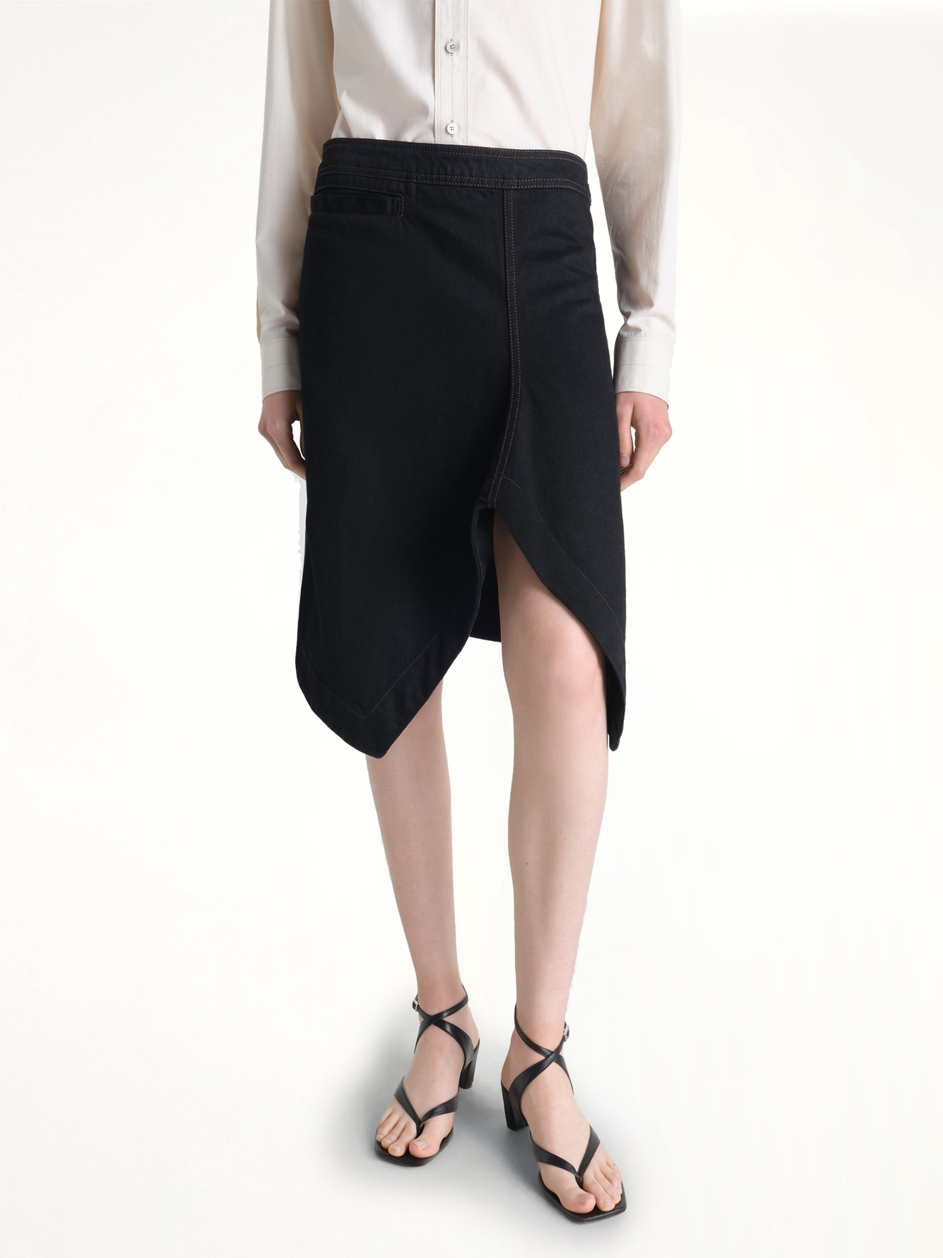 Image of a model wearing Skirts. Product name - Asymmetric Short Skirt in Black colour by brand - LEMAIRE