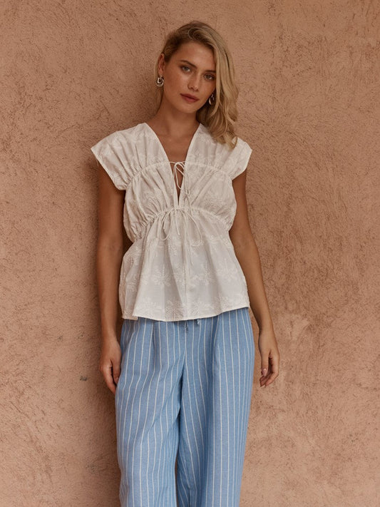 Image of a model wearing Tops. Product name - Bobbie Embroidered Tie Top White in White colour by brand - Sass Clothing