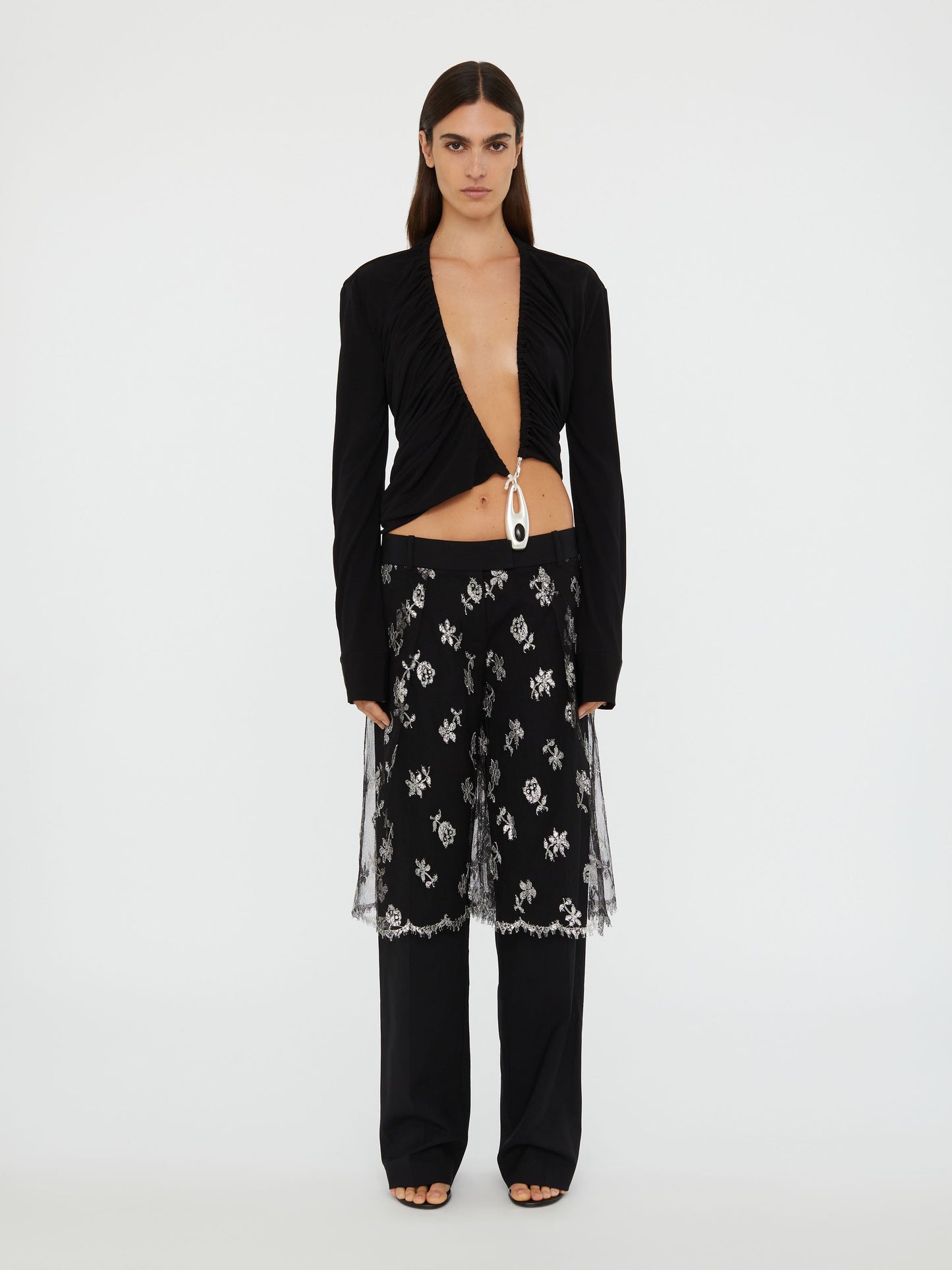 Image of a model wearing Pants. Product name - Lace Sarong Wool Trouser in Black colour by brand - Christopher Esber
