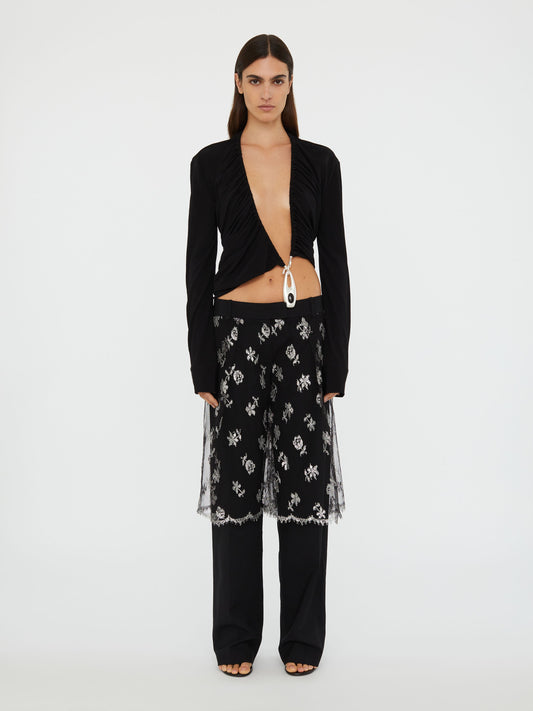 Image of a model wearing Pants. Product name - Lace Sarong Wool Trouser in Black colour by brand - Christopher Esber