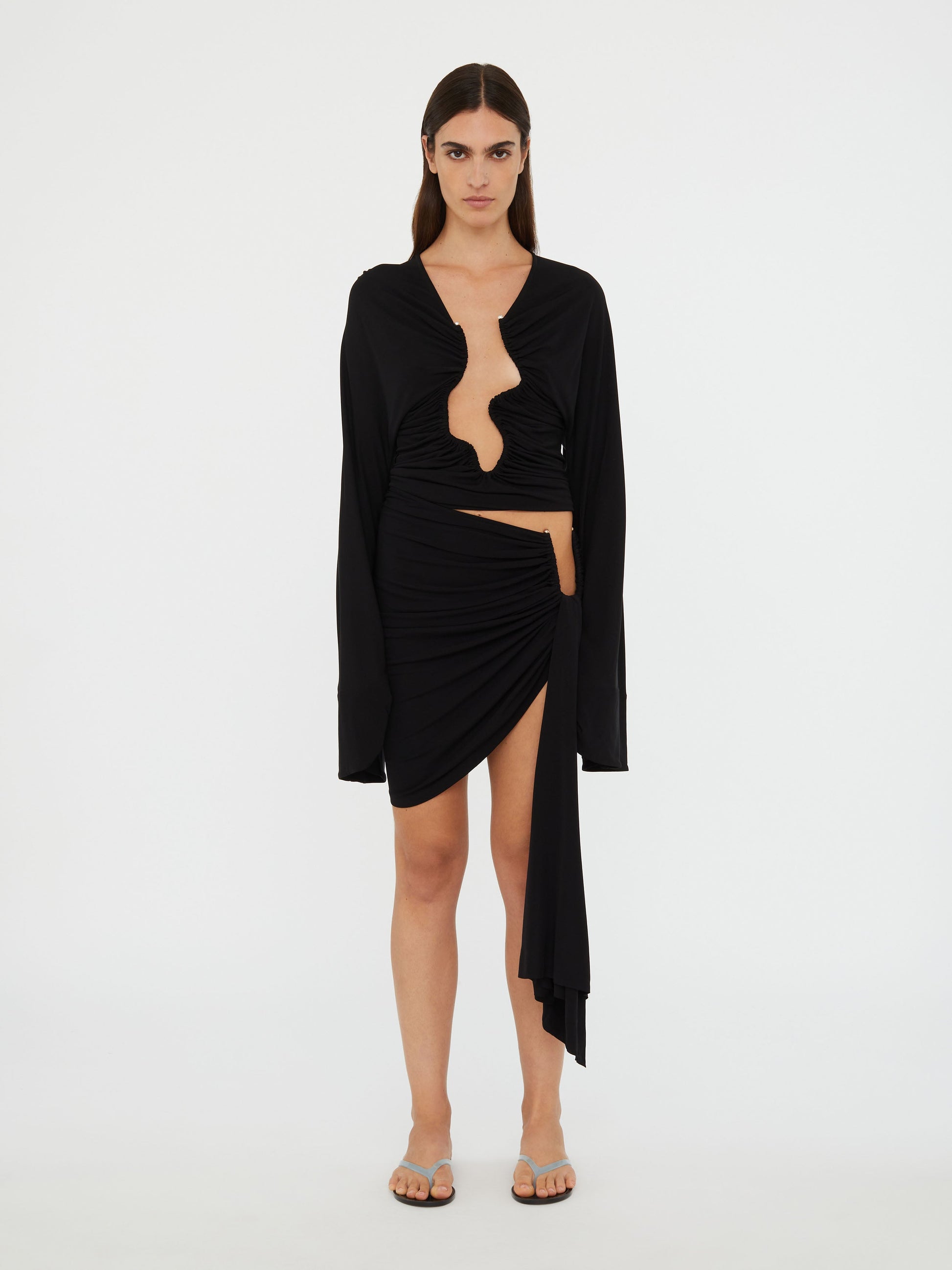 Image of a model wearing Skirts. Productname: Christopher Esber Arced Palm Micro Skirt in Black colour by brand - Christopher Esber