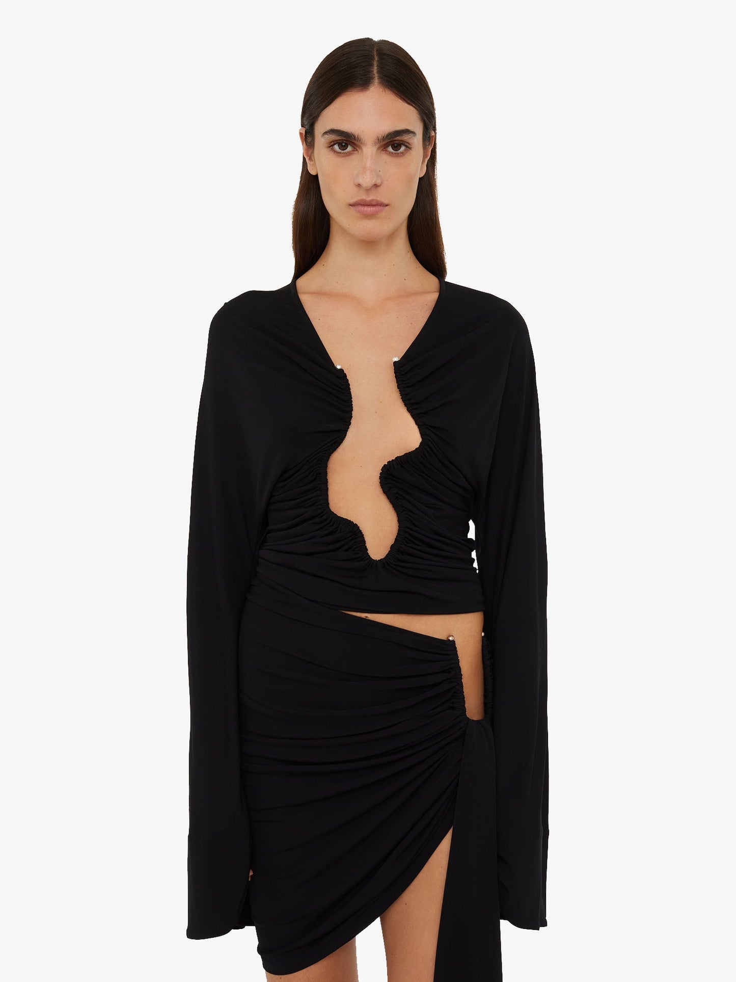 Image of a model wearing Tops. Product name - Salacia Ruched Long Sleeve Top in Top colour by brand - Christopher Esber