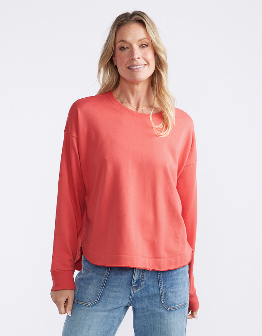 Image of a model wearing Outerwear. Product name - Staple Scoop Hem Sweat Washed Red in Washed Red colour by brand - White & Co.