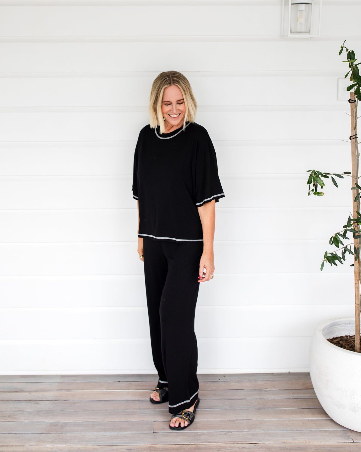Image of a model wearing Tops. Product name - Spears Bamboo T-Shirt Black in Black colour by brand - Lou Lou