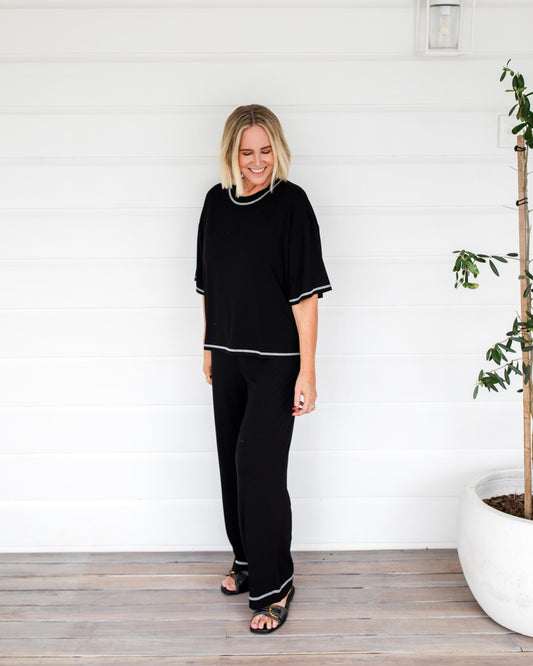 Image of a model wearing Tops. Product name - Spears Bamboo T-Shirt Black in Black colour by brand - Lou Lou