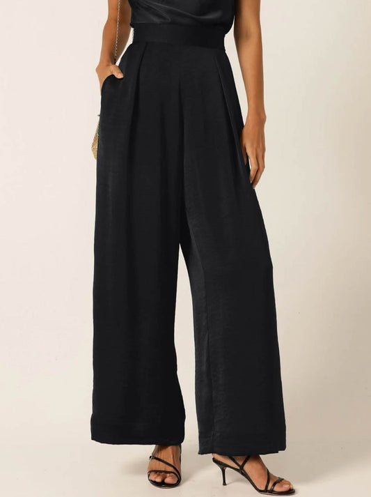 Image of a model wearing Pants. Product name - Sacha Drake Luxe Pleated Trouser in Black colour by brand - Sacha Drake