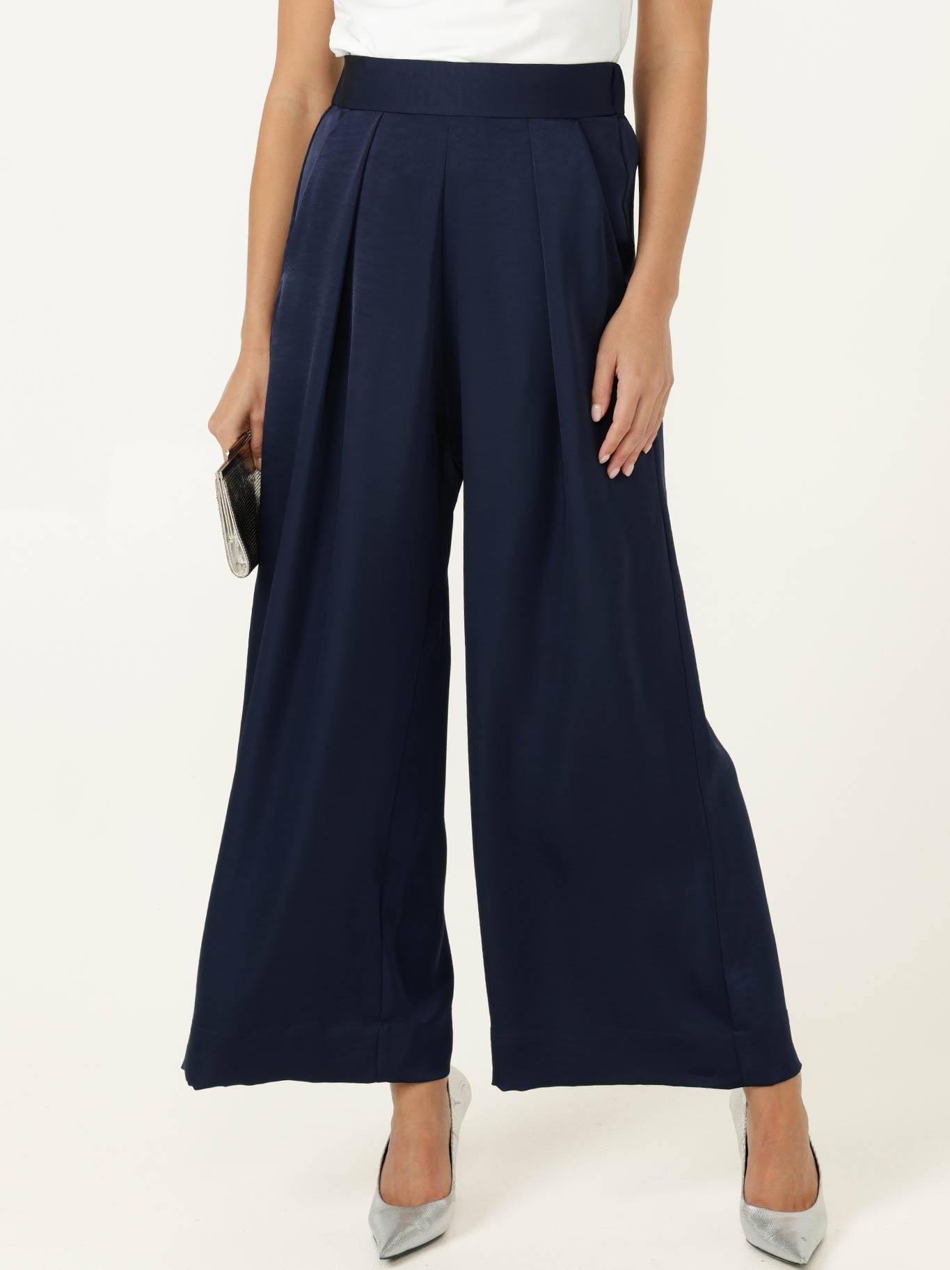 Image of a model wearing Pants. Product name - SACHA DRAKE LUXE PLEATED TROUSER in Navy colour by brand - Sacha Drake