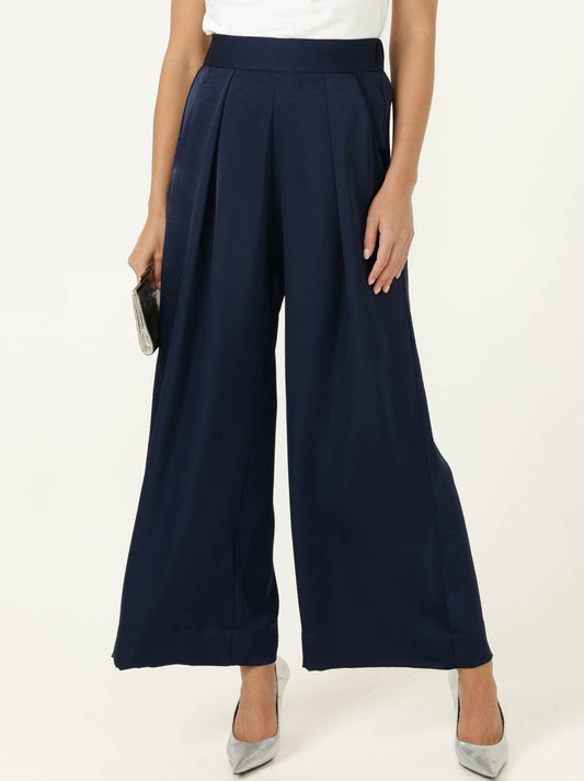 Image of a model wearing Pants. Product name - SACHA DRAKE LUXE PLEATED TROUSER in Navy colour by brand - Sacha Drake