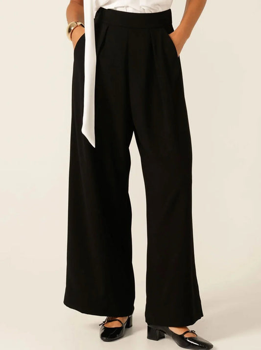 Image of a model wearing Pants. Product name - Sacha Drake Pleated Trouser in Black colour by brand - Sacha Drake Pty Ltd