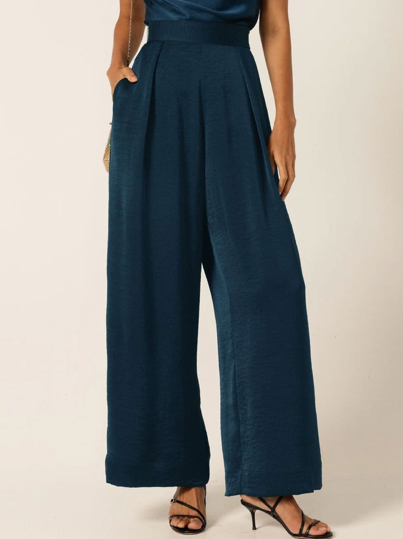Image of a model wearing Pants. Product name - Sacha Drake Pleated Trouser in Steele Blue colour by brand - Sacha Drake Pty Ltd
