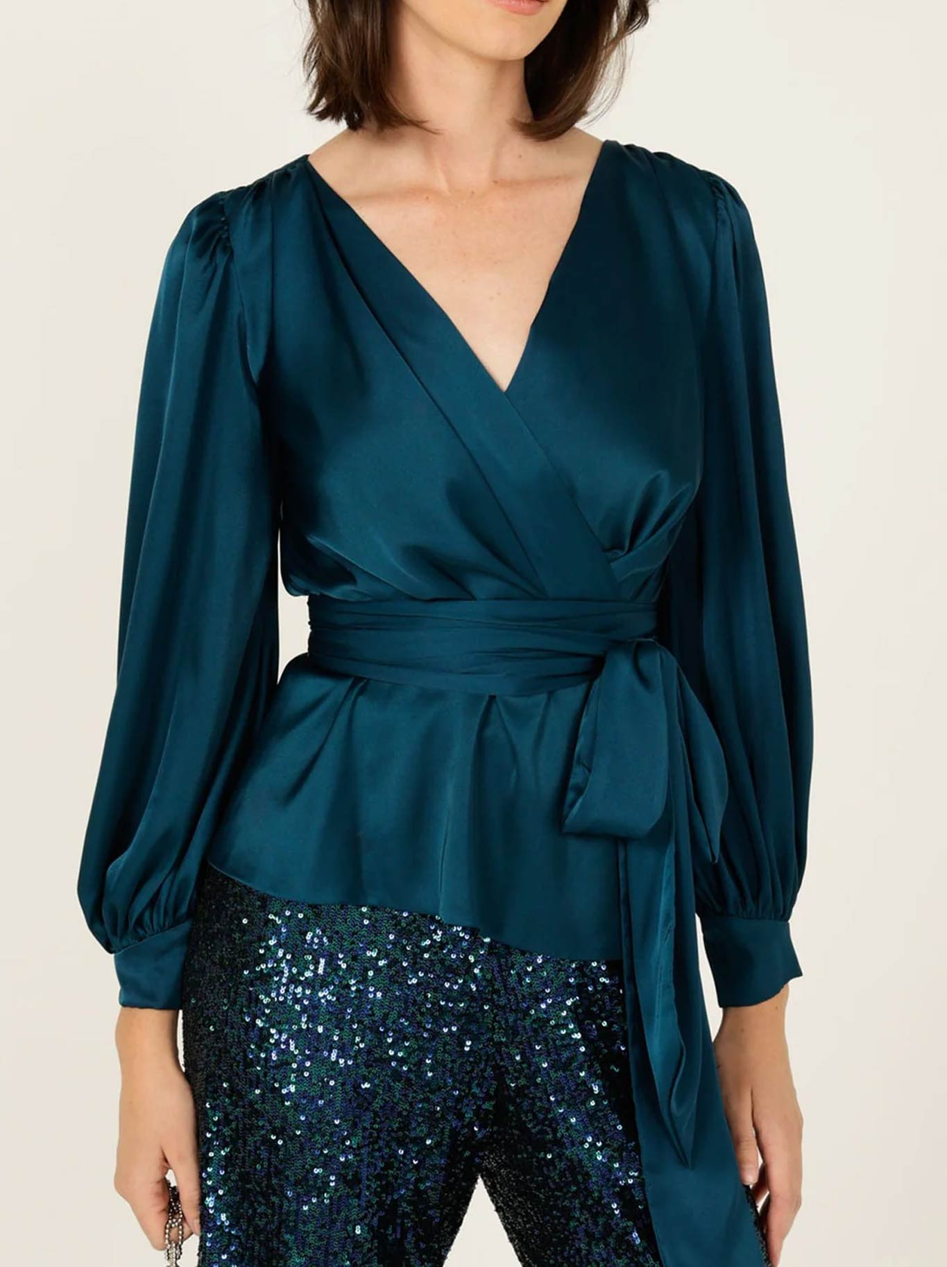 Image of a model wearing Tops. Product name - SACHA DRAKE SATIN FAUX WRAP TOP in Peacock colour by brand - Sacha Drake