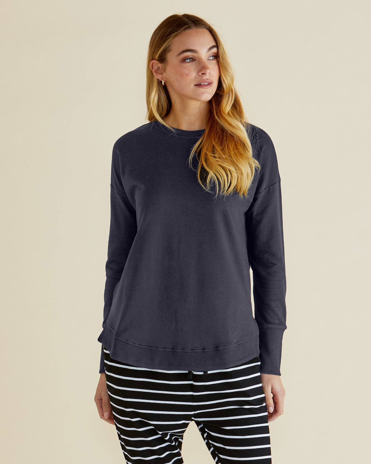Image of a model wearing Tops. Product name - Lucy French Terry Sweat Gunmetal in Gunmetal colour by brand - Betty Basics