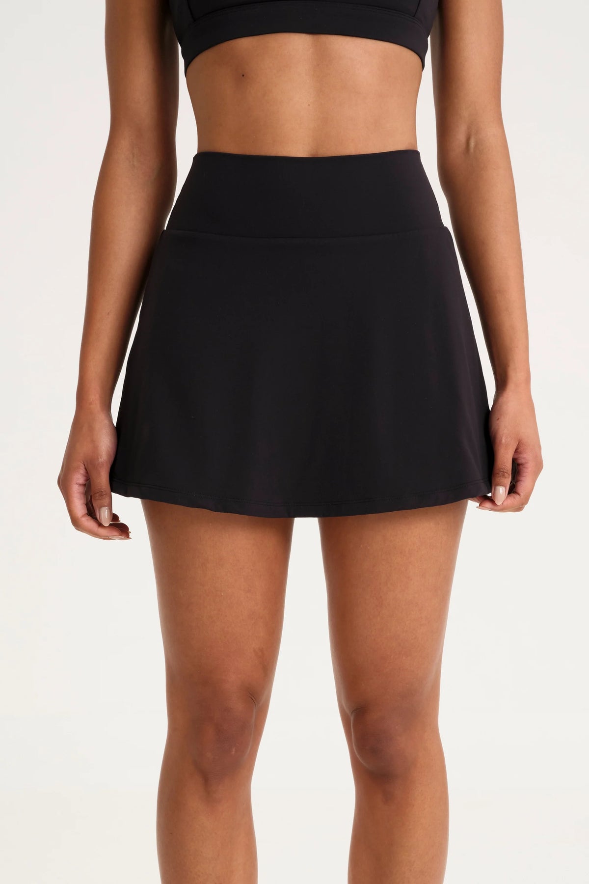 Image of a model wearing Skirts. Product name - ALLFENIX CloudCore Active Skort in Black colour by brand - All Fenix