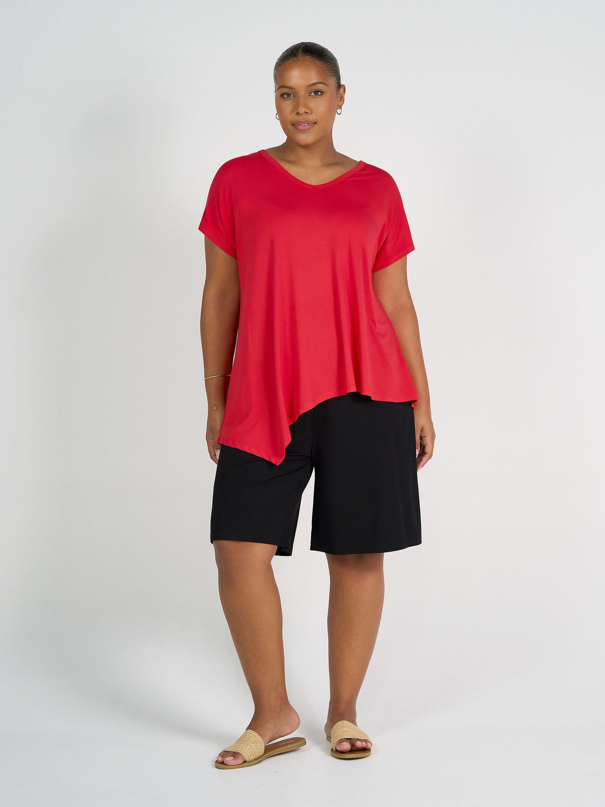 Image of a model wearing Tops. Product name - Holiday Asymmetrical Bamboo V-Neck T-Shirt Lipstick in Lipstick colour by brand - Lou Lou