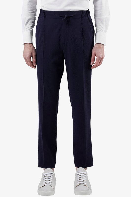 Image of a model wearing Pants. Product name - Sirenuse Navy Drawstring Pant in Navy colour by brand - Anthony Squires