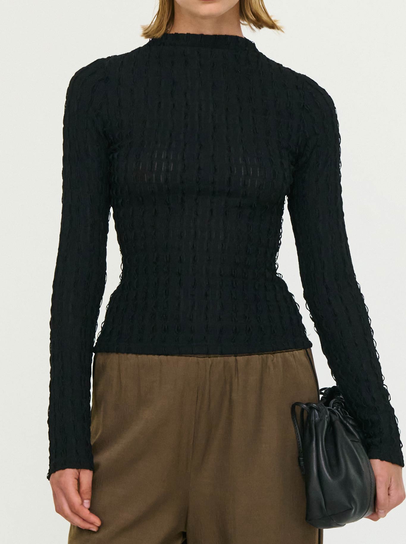 Image of a model wearing Tops. Product name - Staple The Label Drew High Neck Top in Black colour by brand - Staple