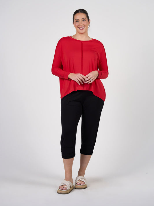 Image of a model wearing Tops. Product name - Stella Longsleeve Oversized Bamboo Slouch Top in Fiery Red colour by brand - Lou Lou