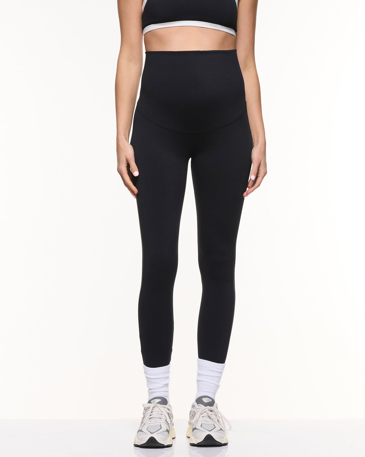 Image of a model wearing Pants. Product name - Super Stretch Foldover Leggings in Black colour by brand - Soon Maternity