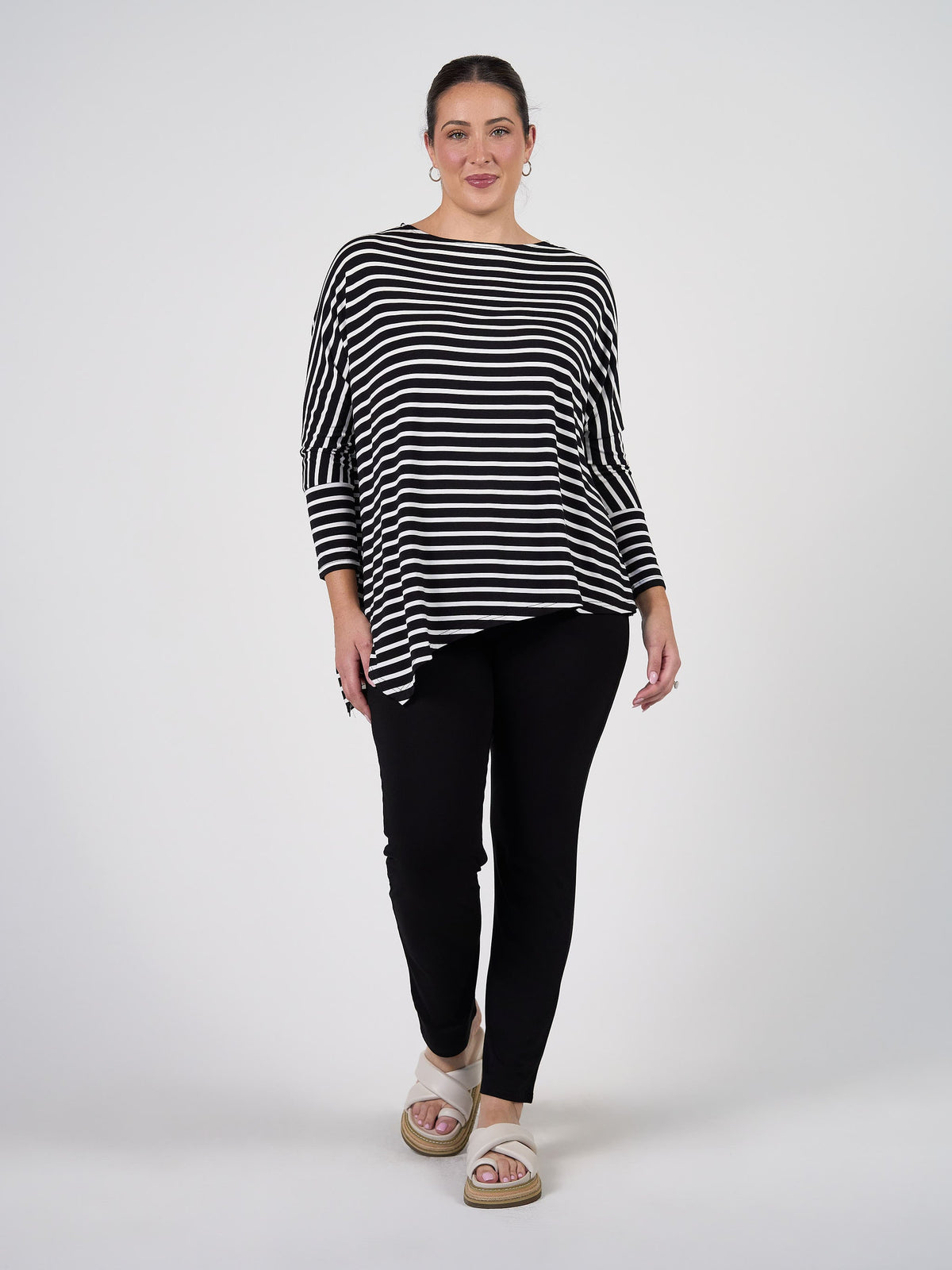 Image of a model wearing Tops. Product name - Susie Oversized Asymmetrical Bamboo Top Black & White Stripe in Black & White Stripe colour by brand - Lou Lou