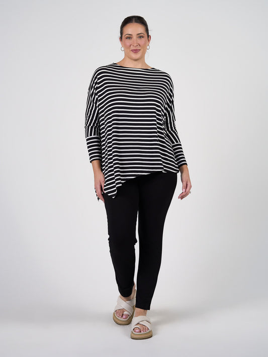 Image of a model wearing Tops. Product name - Susie Oversized Asymmetrical Bamboo Top Black & White Stripe in Black & White Stripe colour by brand - Lou Lou