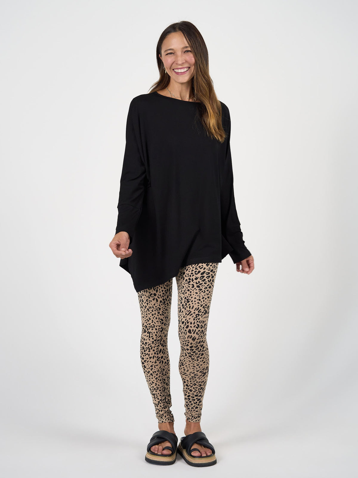 Image of a model wearing Tops. Product name - Susie Oversized Asymmetrical Bamboo Top in Black colour by brand - Lou Lou