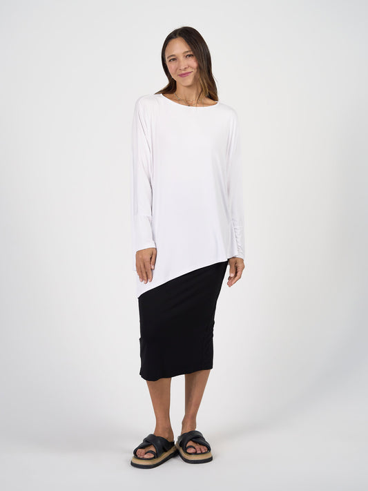 Image of a model wearing Tops. Product name - Susie Oversized Asymmetrical Bamboo Top White in White colour by brand - Lou Lou