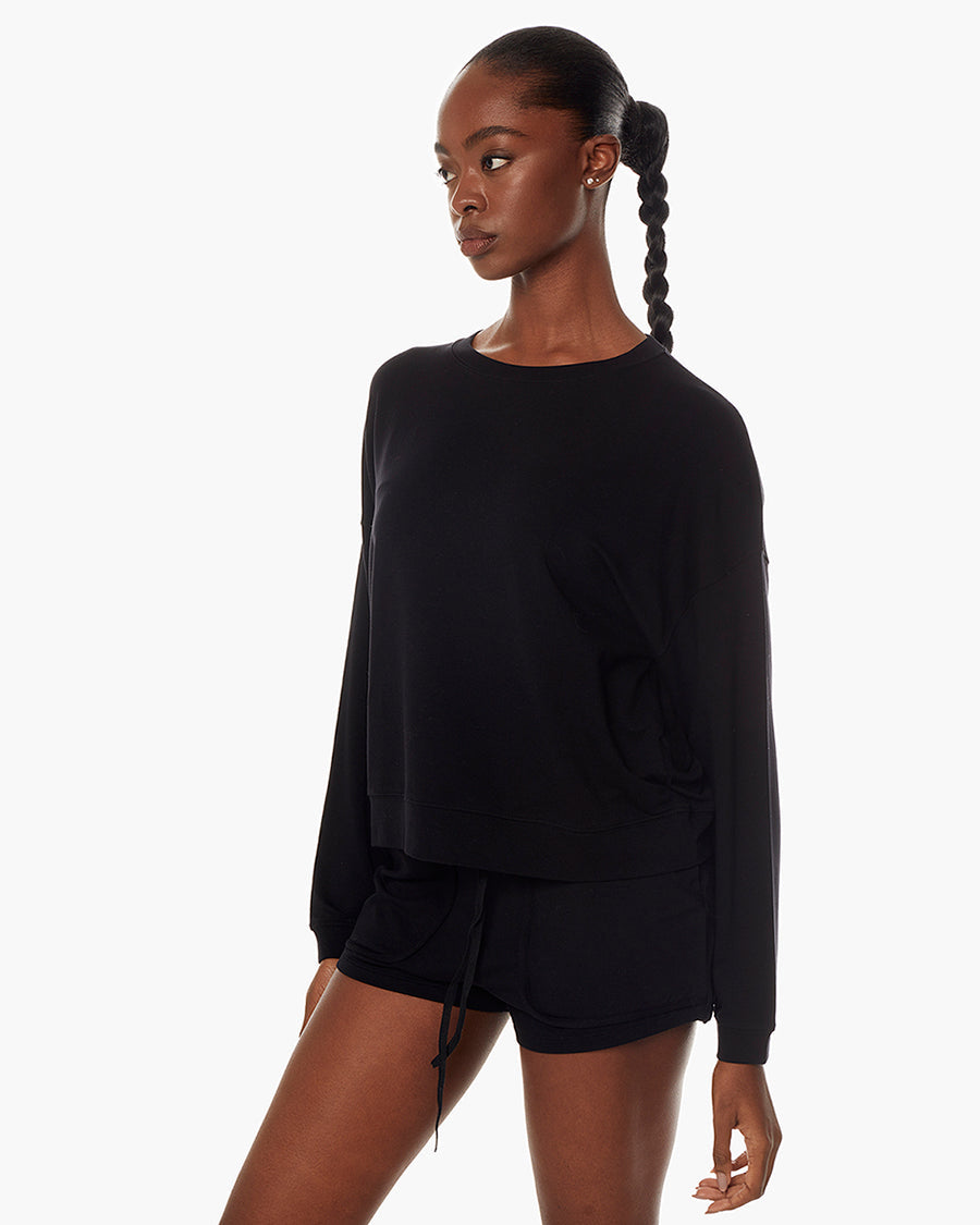 Image of a model wearing Tops. Productname: Coucher de Soleil Crew Black in Black colour by brand - TKEES