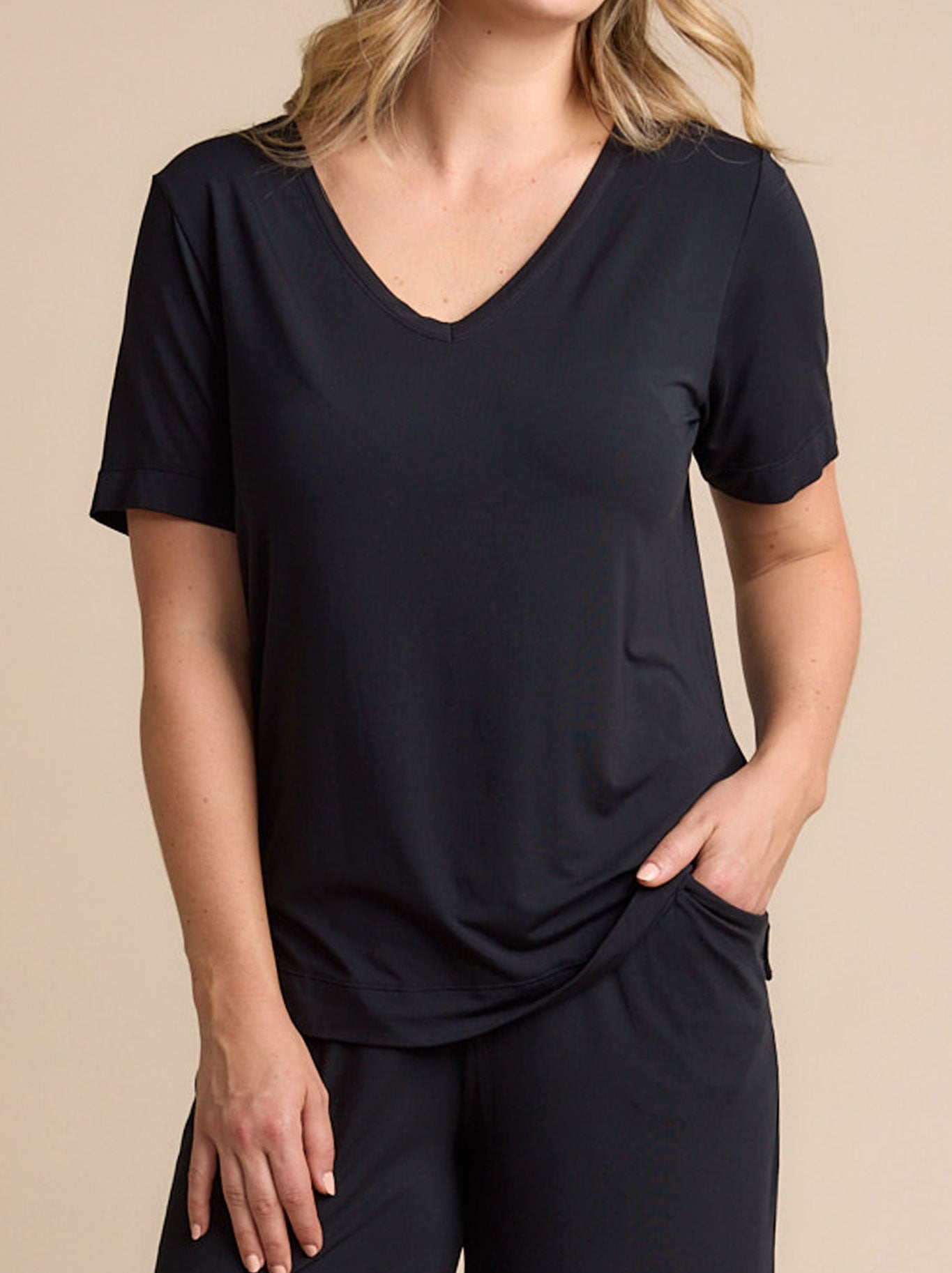 Image of a model wearing Tops. Productname: TANI ELLA V NECK TEE in Black colour by brand - Tani