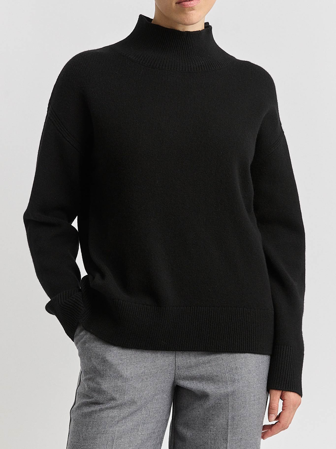 Image of a model wearing Tops. Product name - TOORALLIE SPLIT NECK FUNNEL in Black colour by brand - Toorallie