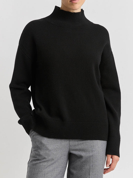 Image of a model wearing Tops. Product name - TOORALLIE SPLIT NECK FUNNEL in Black colour by brand - Toorallie