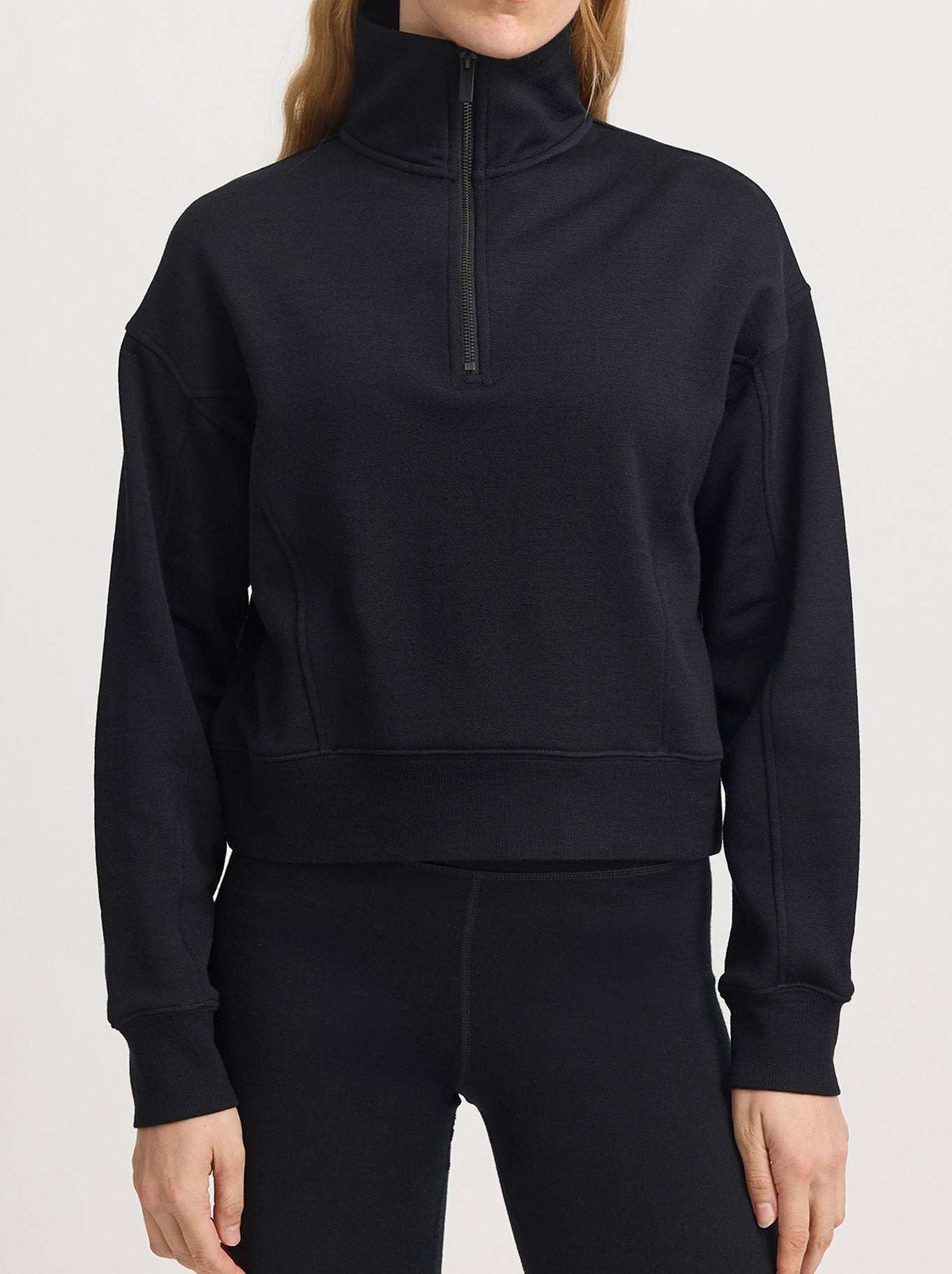 Image of a model wearing Tops. Product name - Toorallie Lounge Cropped Half Zip in Black colour by brand - Toorallie