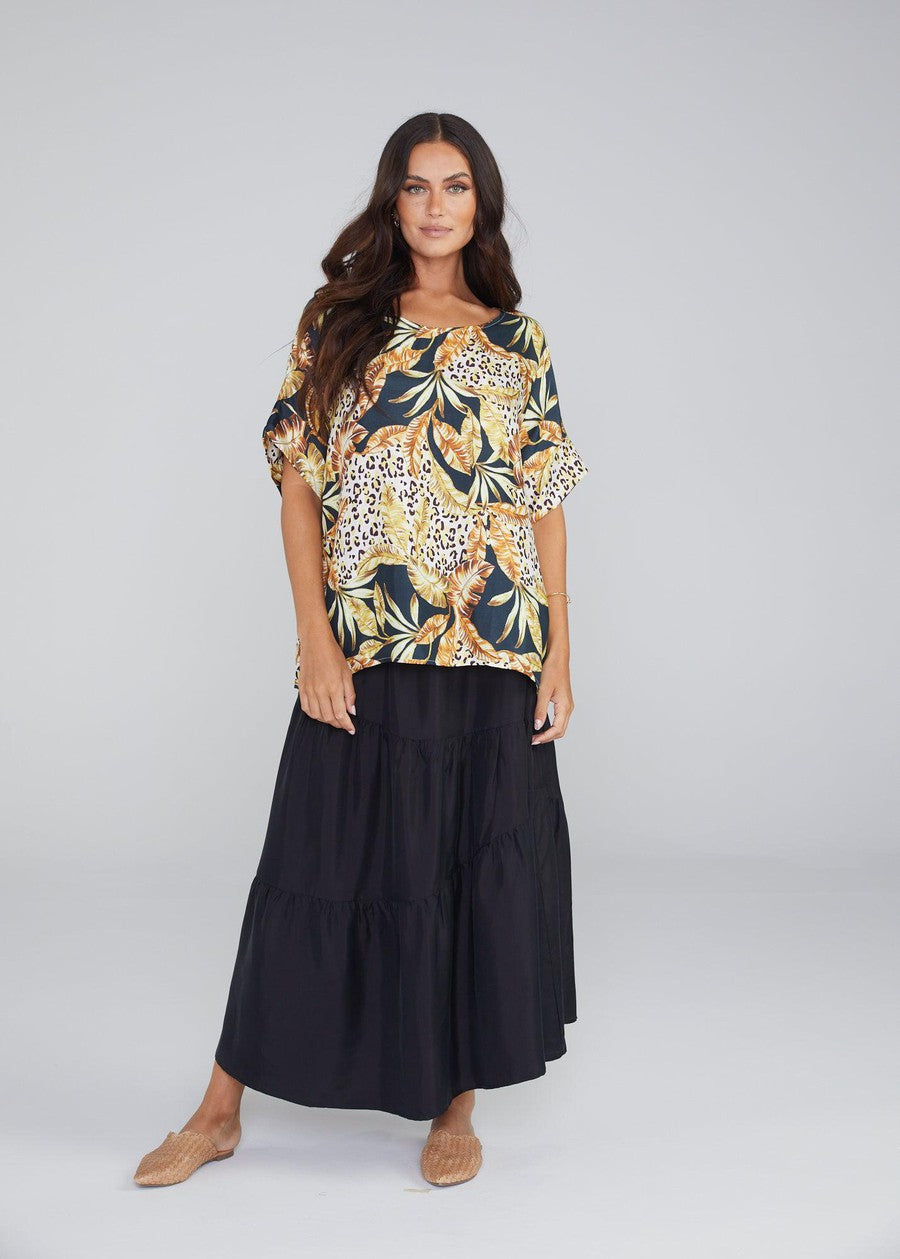 Image of a model wearing Tops. Product name - Dua Oversized Silk Top in Black Leaf colour by brand - Lou Lou